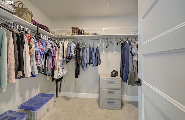 spacious closet featuring light colored carpet