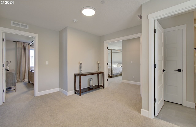 hall featuring light colored carpet