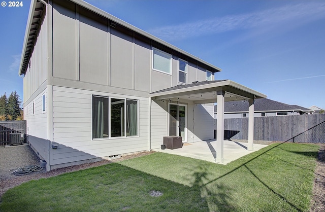 rear view of house with a patio, a yard, and central air condition unit