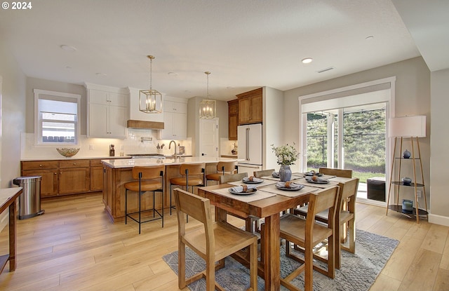 dining area with sink and light hardwood / wood-style floors