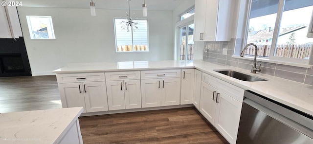 kitchen featuring dishwasher, sink, hanging light fixtures, dark hardwood / wood-style floors, and white cabinetry