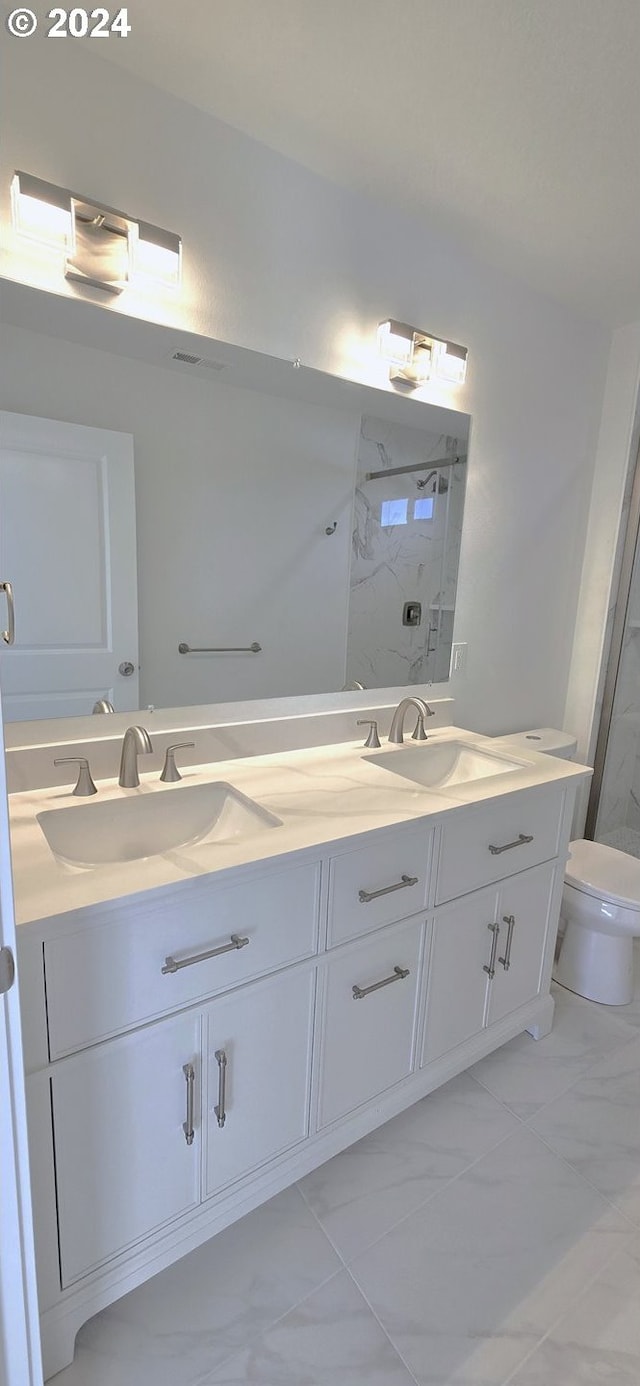 bathroom featuring tiled shower, vanity, and toilet