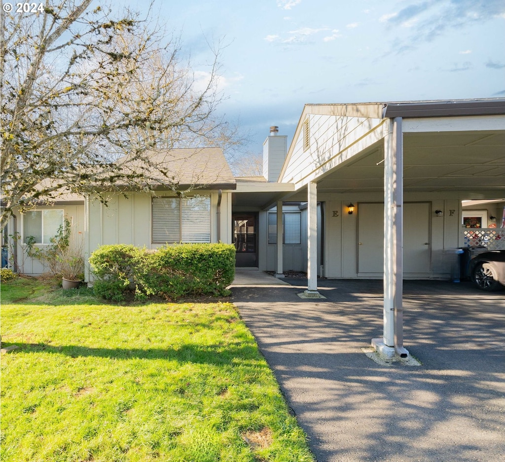 view of front facade with a carport and a front lawn