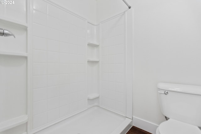 bathroom featuring toilet and a tile shower