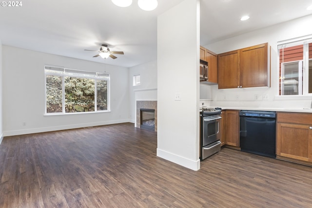 kitchen with ceiling fan, sink, dark hardwood / wood-style floors, a fireplace, and appliances with stainless steel finishes