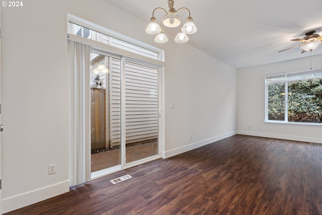 empty room featuring dark wood-type flooring and ceiling fan with notable chandelier