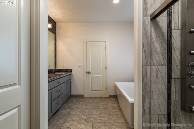 bathroom with vanity and tiled bath