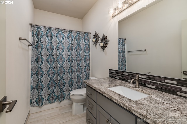 bathroom with vanity, toilet, and decorative backsplash