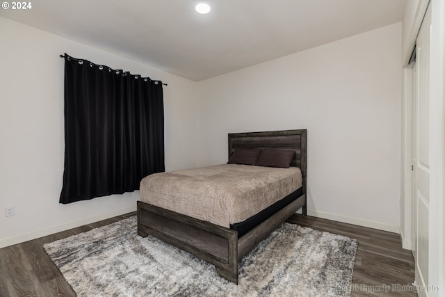 bedroom with dark hardwood / wood-style flooring and a closet