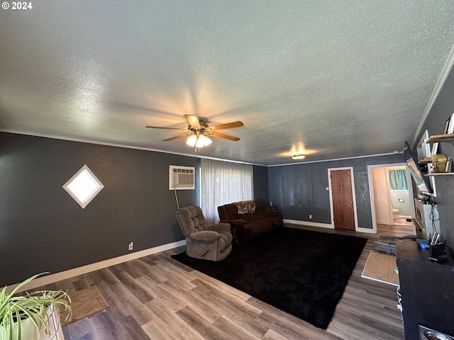 living room with a textured ceiling, ceiling fan, hardwood / wood-style floors, and a wall mounted air conditioner