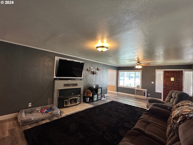 living room with a textured ceiling, hardwood / wood-style flooring, ceiling fan, and ornamental molding