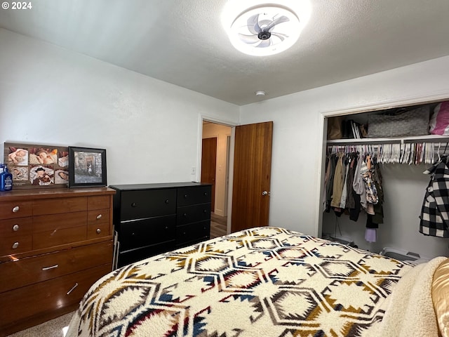 bedroom with carpet flooring, a closet, and a textured ceiling