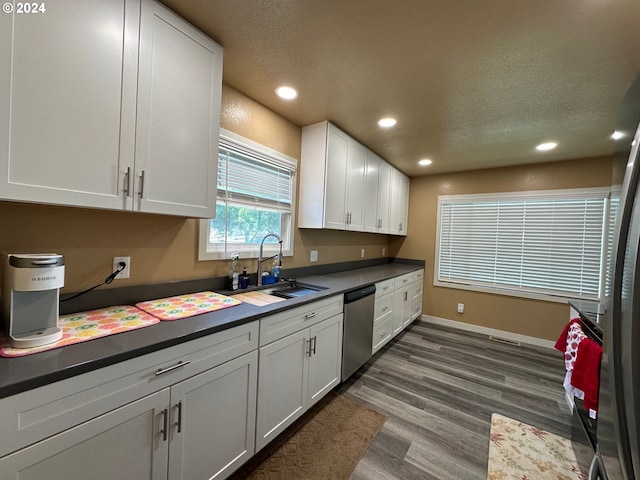 kitchen featuring dishwasher, dark wood-type flooring, white cabinets, sink, and a textured ceiling