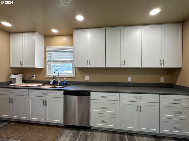 kitchen with dark hardwood / wood-style flooring, dishwasher, white cabinets, and sink