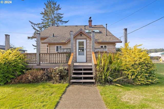 bungalow-style house featuring a front lawn and a deck