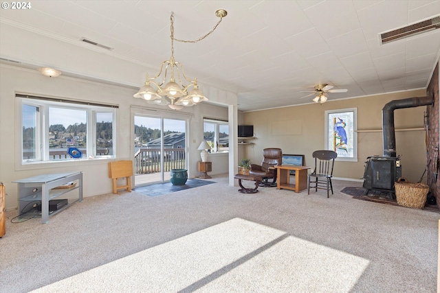 3770 NE 12th St, Otis, OR 97368 - interior space featuring visible vents, carpet, a wood stove, and ceiling fan with notable chandelier