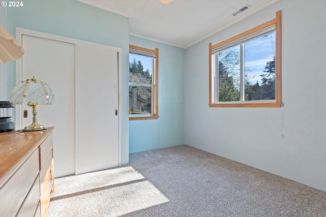 carpeted bedroom with a closet and ornamental molding