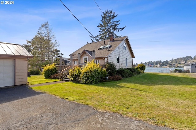 view of home's exterior with a deck with water view and a yard