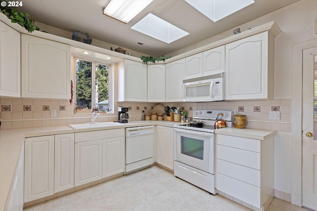 3770 NE 12th St, Otis, OR 97368 - kitchen featuring a sink, decorative backsplash, a skylight, and white appliances