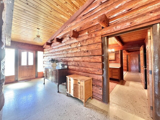 interior space with lofted ceiling, rustic walls, and wooden ceiling