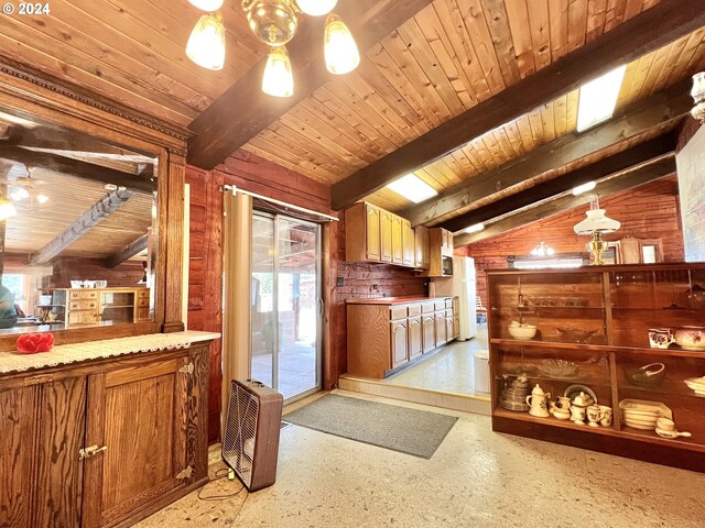 kitchen featuring wooden walls, lofted ceiling with beams, and a wealth of natural light