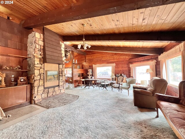 carpeted living room with vaulted ceiling with beams, wood ceiling, wooden walls, and a wealth of natural light