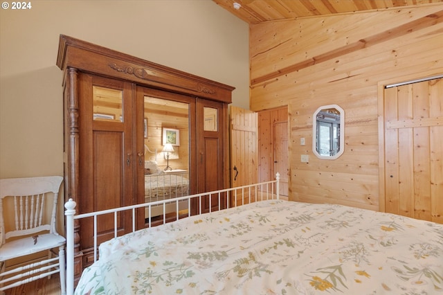 unfurnished bedroom with high vaulted ceiling and wood walls