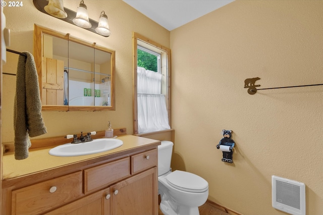 bathroom with vanity, toilet, and heating unit