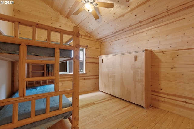 bedroom featuring wood ceiling, lofted ceiling, light hardwood / wood-style flooring, and wood walls