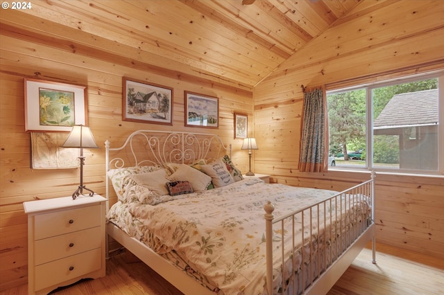 bedroom with wood ceiling, lofted ceiling, light hardwood / wood-style flooring, and wood walls