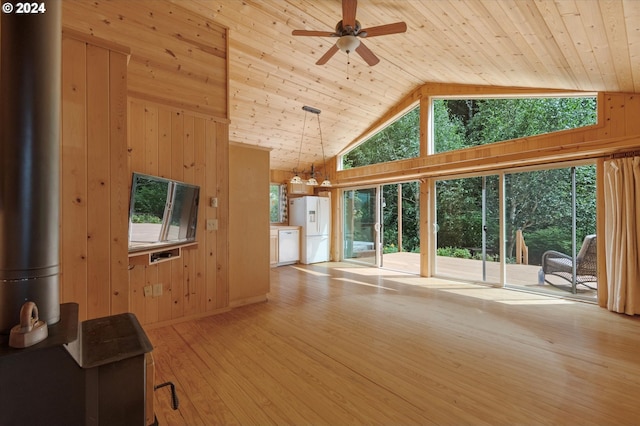 unfurnished living room with high vaulted ceiling, wooden ceiling, wooden walls, and light hardwood / wood-style flooring