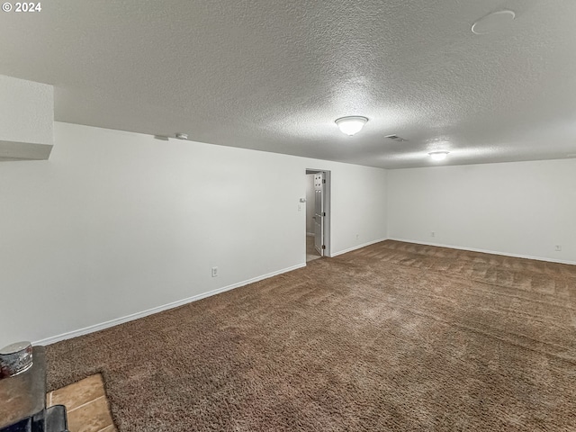 unfurnished room featuring carpet and a textured ceiling