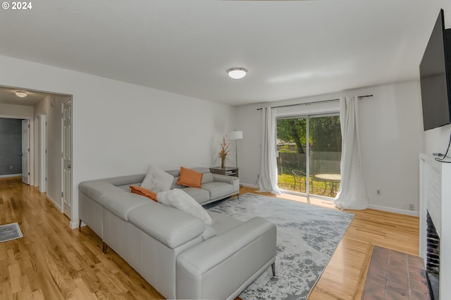 living room featuring light hardwood / wood-style flooring and a fireplace