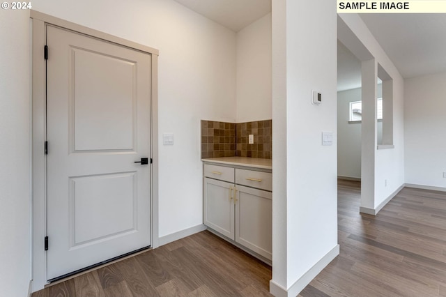 kitchen featuring white cabinets, light hardwood / wood-style floors, and backsplash