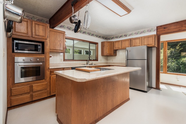 kitchen featuring stainless steel appliances, plenty of natural light, sink, and a kitchen island