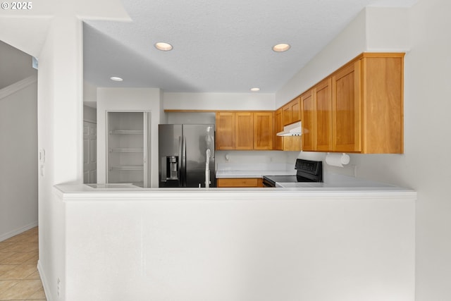 kitchen with stainless steel fridge, electric range, a textured ceiling, light tile patterned flooring, and kitchen peninsula