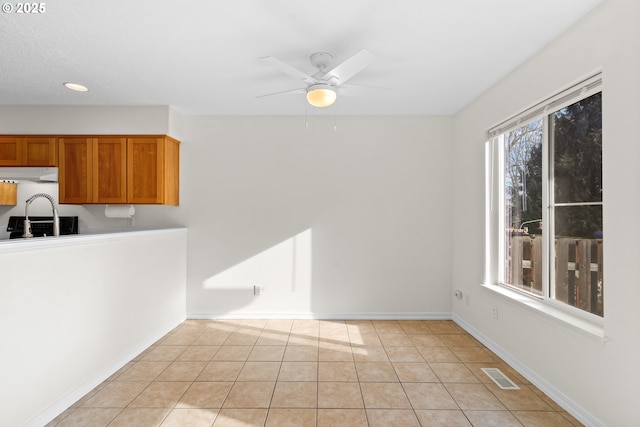 interior space with light tile patterned flooring and ceiling fan