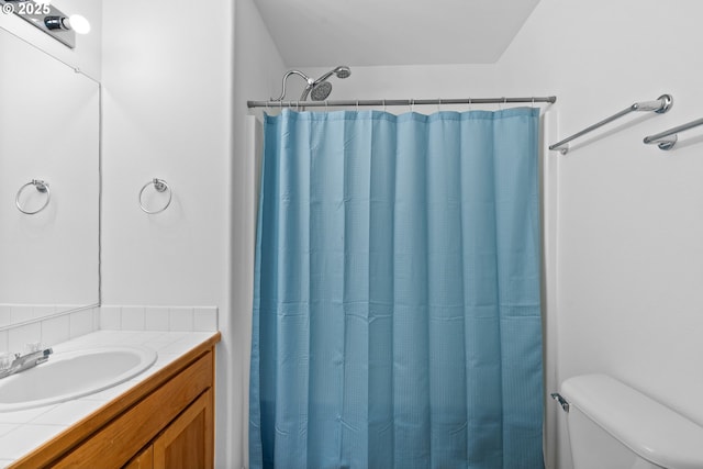 bathroom featuring walk in shower, vanity, and toilet