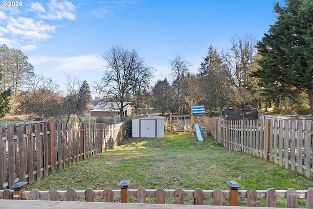 view of yard featuring a playground and a shed