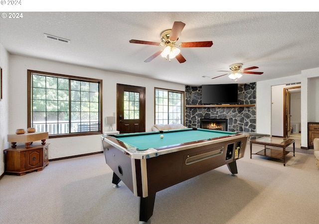 game room featuring visible vents, a fireplace, light carpet, and a textured ceiling