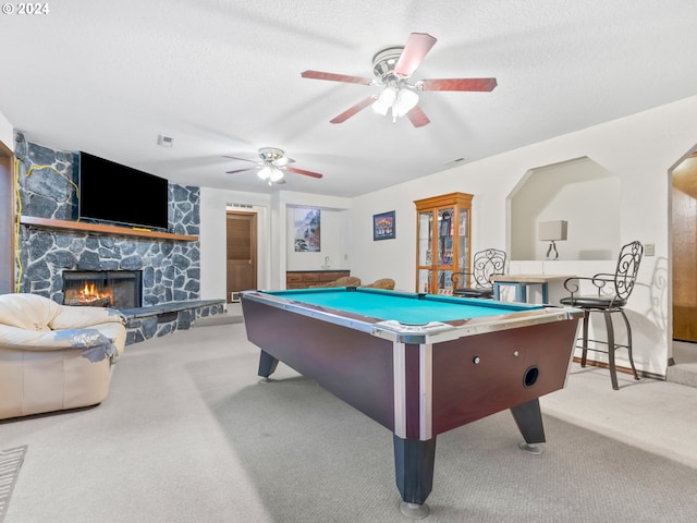 rec room with light carpet, a textured ceiling, a fireplace, and visible vents