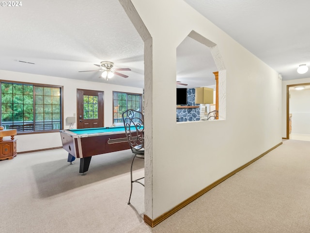 game room with a textured ceiling, plenty of natural light, baseboards, and light colored carpet