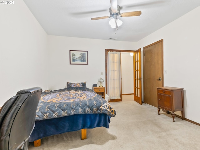 bedroom featuring ceiling fan, light colored carpet, visible vents, baseboards, and french doors