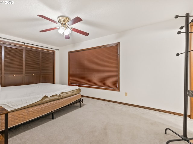 carpeted bedroom featuring ceiling fan and baseboards