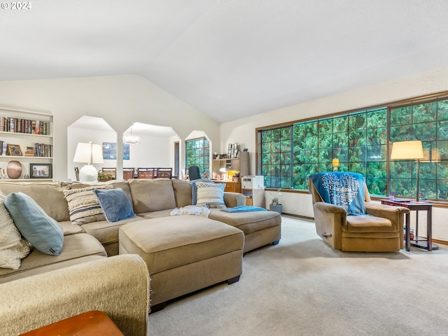 living area with a chandelier, lofted ceiling, and light colored carpet