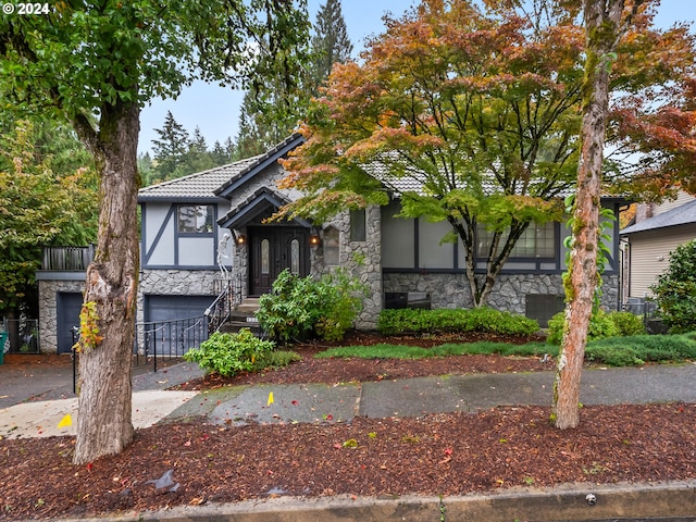 view of front of property with a garage, a tile roof, stone siding, driveway, and stucco siding