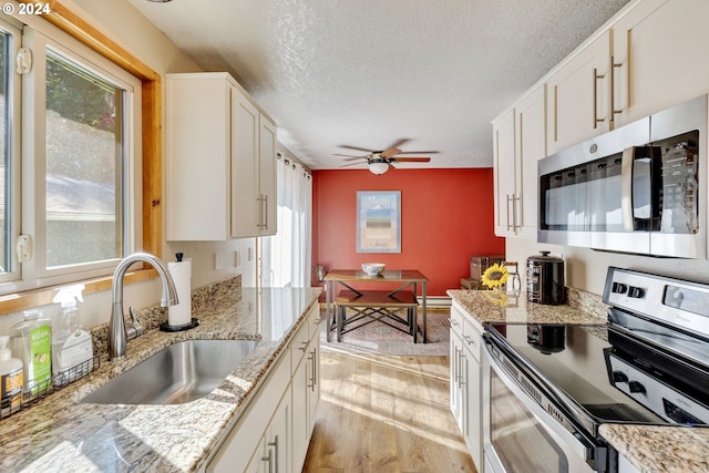 kitchen featuring sink, white cabinetry, light hardwood / wood-style flooring, and appliances with stainless steel finishes