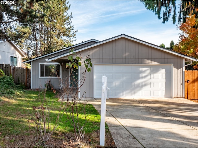 single story home featuring a front lawn and a garage