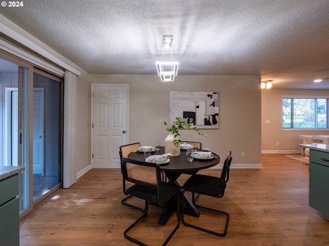 dining area featuring a textured ceiling and light wood-type flooring