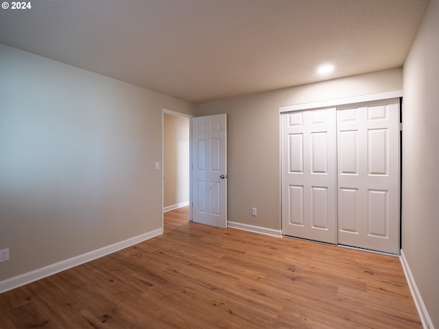 unfurnished bedroom featuring light wood-type flooring and a closet